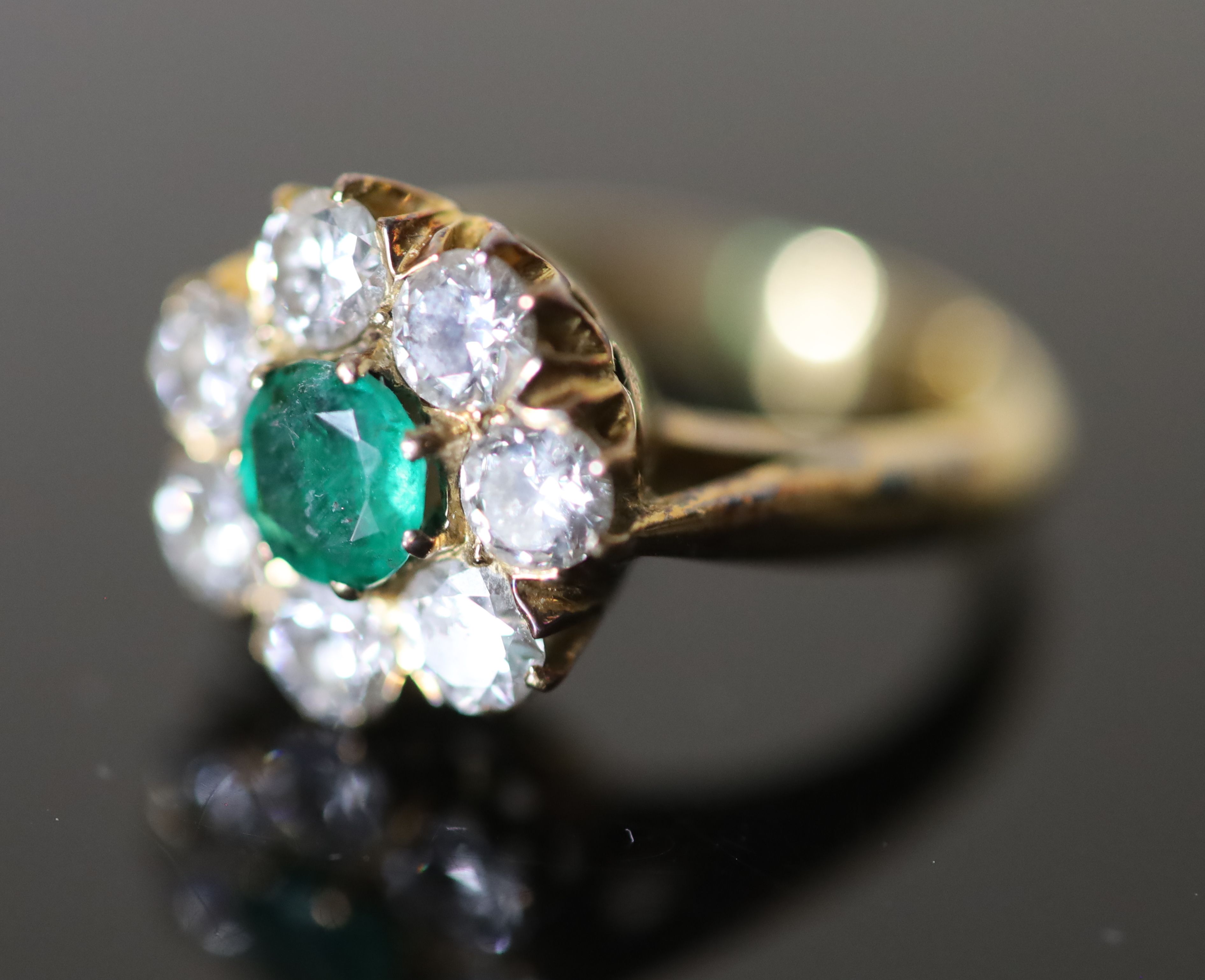 A 20th century gold, emerald and diamond set circular eight stone cluster ring,